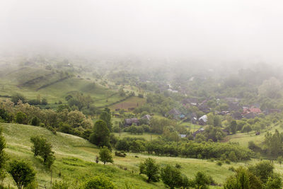 Scenic view of landscape against sky during foggy weather