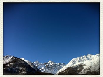 Scenic view of snow covered mountains against clear sky