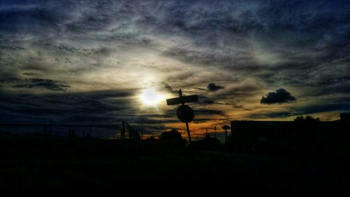 Silhouette landscape against cloudy sky during sunset