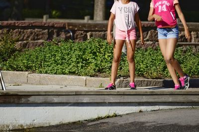 Low section of women walking on footpath