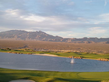 Scenic view of lake by mountains against sky