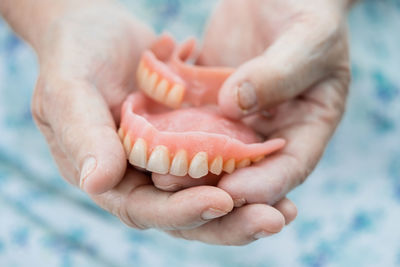 Asian senior woman patient holding to use denture in nursing hospital 