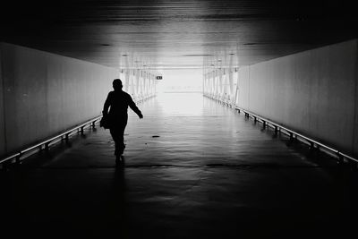 Full length of silhouette man walking in tunnel