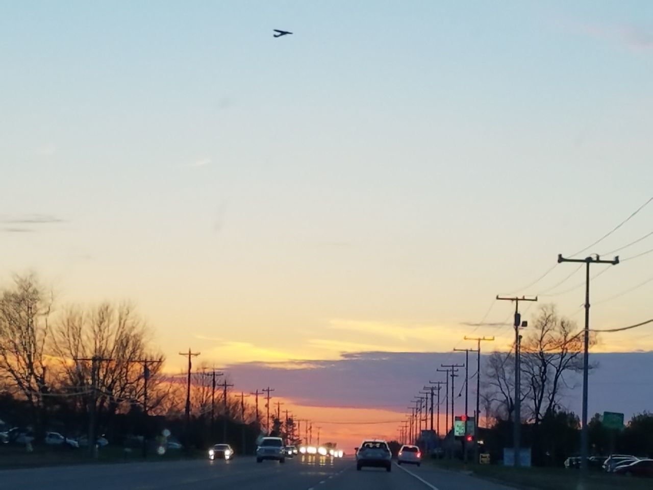 CARS ON ROAD AGAINST SKY AT SUNSET