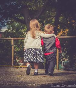 Rear view of girl walking on tree