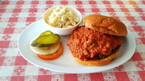 High angle view of hamburger with pasta and salad in plate on table