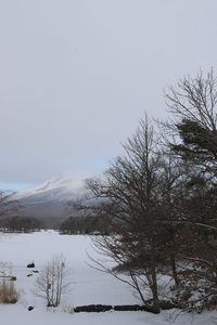 Scenic view of snow covered field against sky