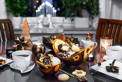 Dining room  table  with bronze and black decorative elements. homemade baked cookies and coffee.