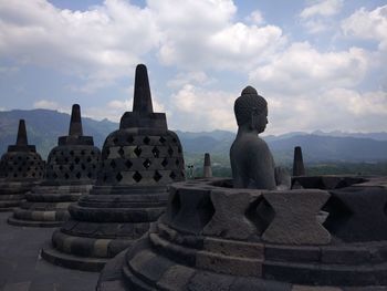 Statue of temple against cloudy sky