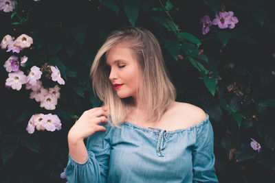 Portrait of beautiful woman with pink flower