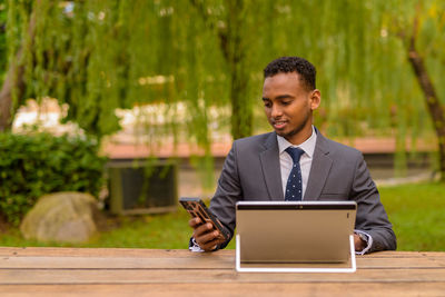 Man using mobile phone while sitting on table