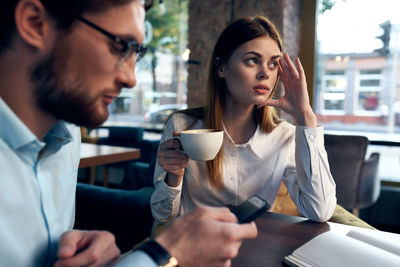 Young couple sitting on table at cafe