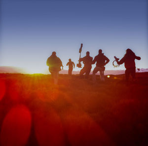 Men with arms raised against clear sky