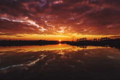 Scenic view of sea against cloudy sky at sunset