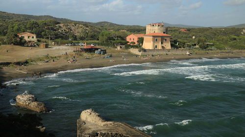 Scenic view of beach by buildings against sky