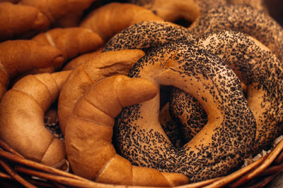 Fresh baked bread buns with poppy seeds in a wicker basket. bakery shop counter