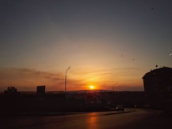 Silhouette city against sky during sunset