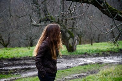 Woman looking away while standing on field