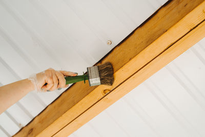 Covering the protective varnish of the wooden terrace.  there's a big paintbrush in your hand.