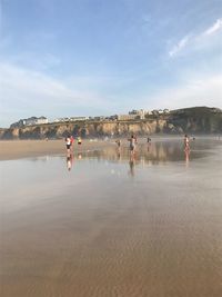 People on beach against sky