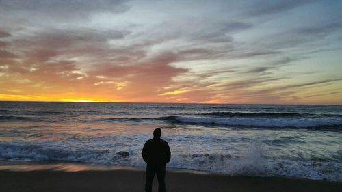 Rear view of man standing on beach