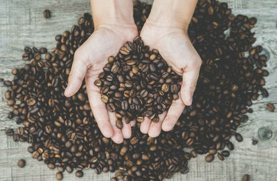 High angle view of hand holding coffee beans