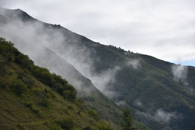 Scenic view of mountains against cloudy sky