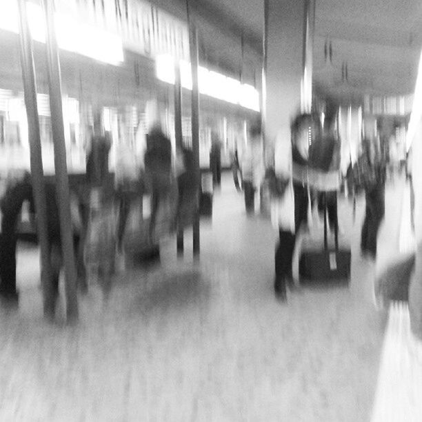 indoors, in a row, selective focus, flooring, men, person, illuminated, reflection, walking, corridor, lifestyles, incidental people, focus on foreground, large group of people, medium group of people, repetition, blurred motion, surface level, group of people
