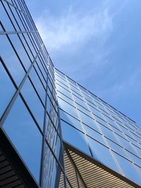 Low angle view of glass building against sky