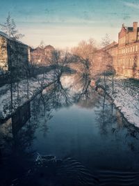 View of frozen river in city during winter