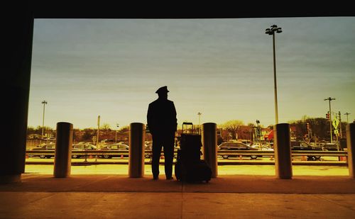 Rear view full length of man standing with luggage at airport