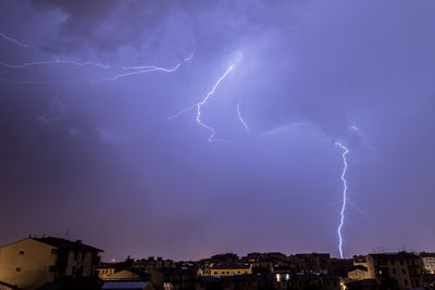 Lightning over cityscape against dramatic sky