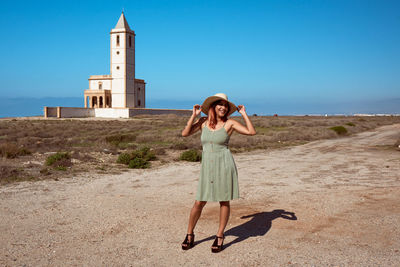 Full length of woman standing on land against sky