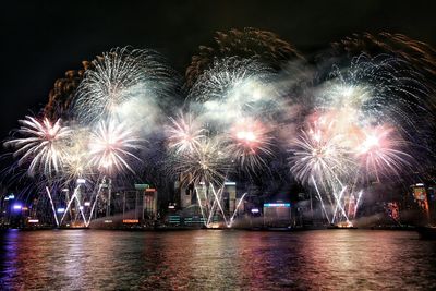 Low angle view of firework display at harbor during night