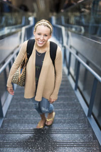 Portrait of smiling woman walking on steps