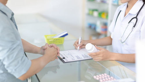 Midsection of doctor working on table