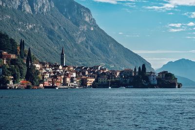 Scenic view of town by sea against sky