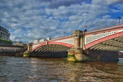 View of bridge over river against cloudy sky