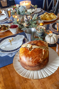 Panettone bread with cherries and whipped cream on a holiday table at christmas.
