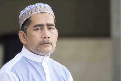 Close-up portrait of man standing at mosque