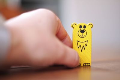 Close-up of hand holding yellow toy