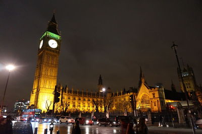 Low angle view of clock tower at night