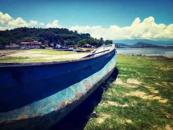 Boats in river against cloudy sky