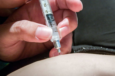 Nurse injecting into abdomen