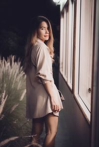 Young woman standing against wall