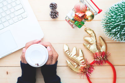 High angle view of woman holding tea cup on table