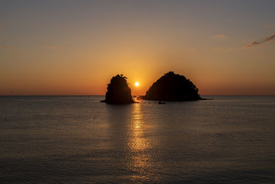 Scenic view of sea against romantic sky at sunset