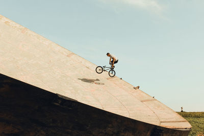 Man riding bicycle against sky