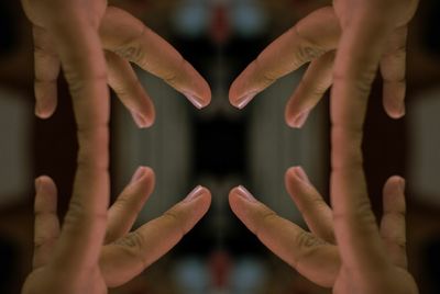 Cropped image of hands reflecting in mirror