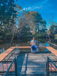 Man sitting on bench against trees